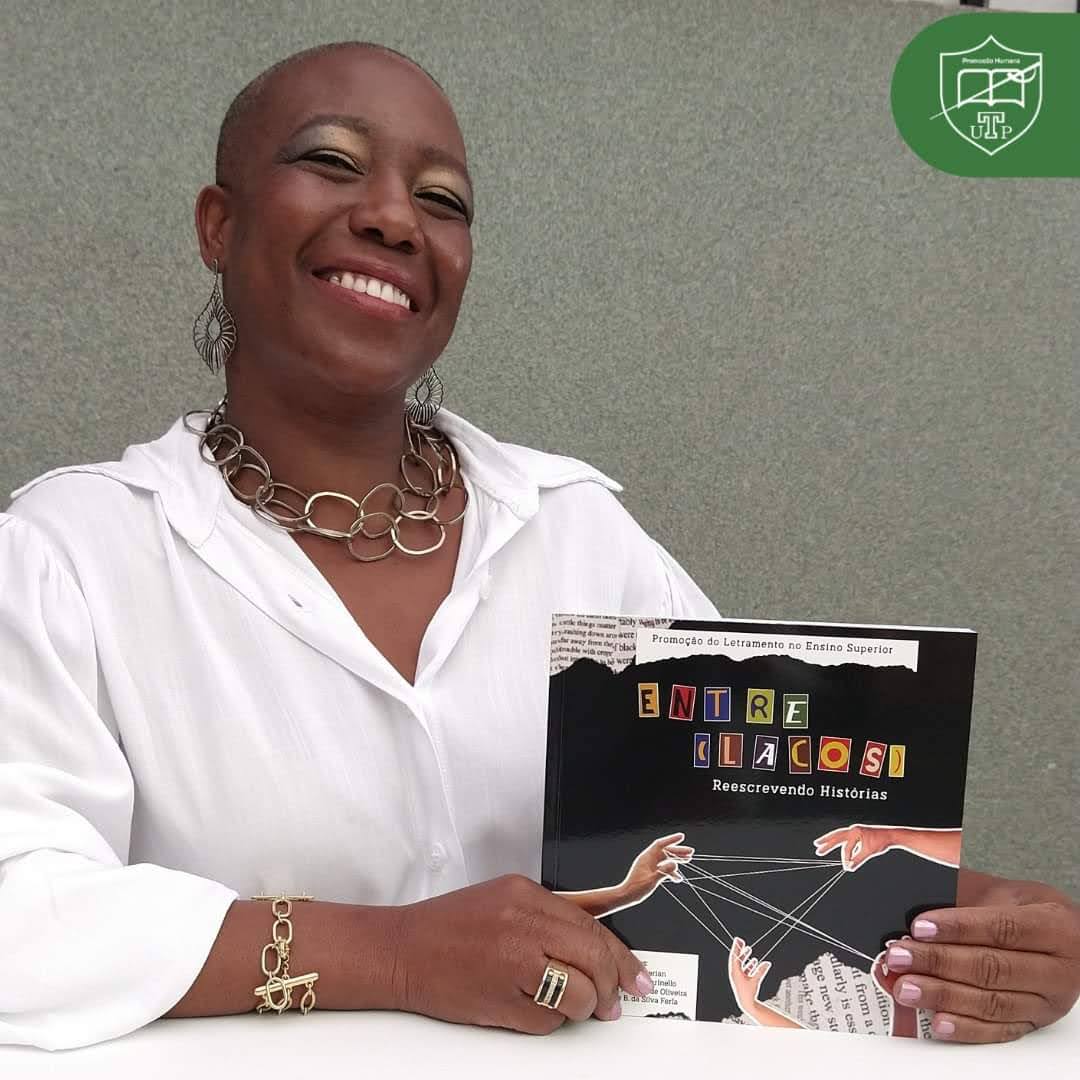 Fono Clau segurando livro publicado com sua participação